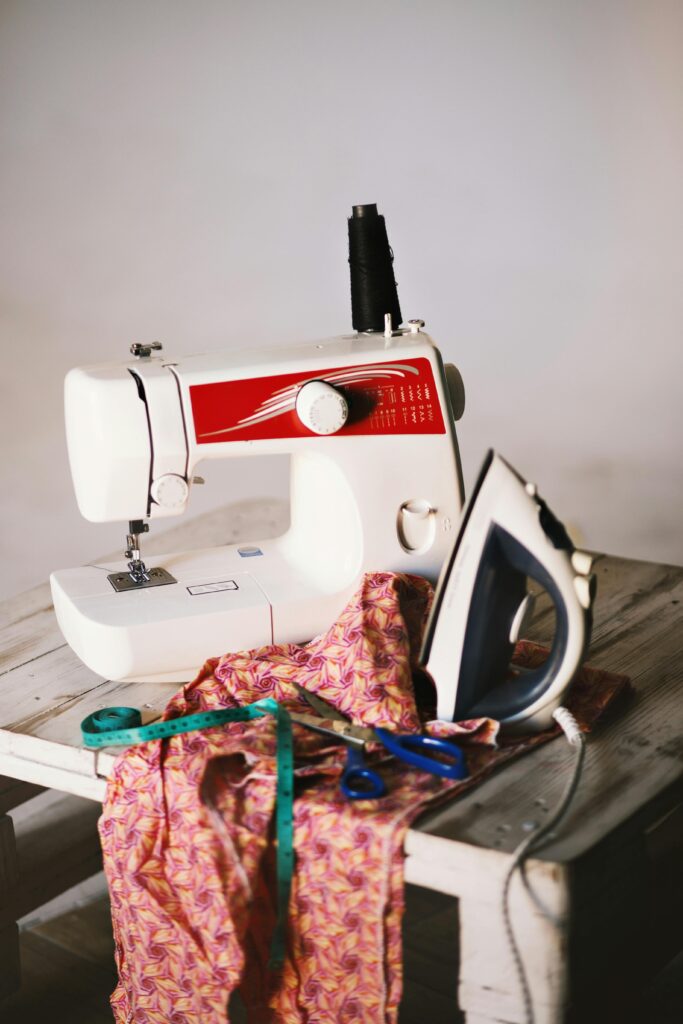 White sewing machine clothes iron and scissors